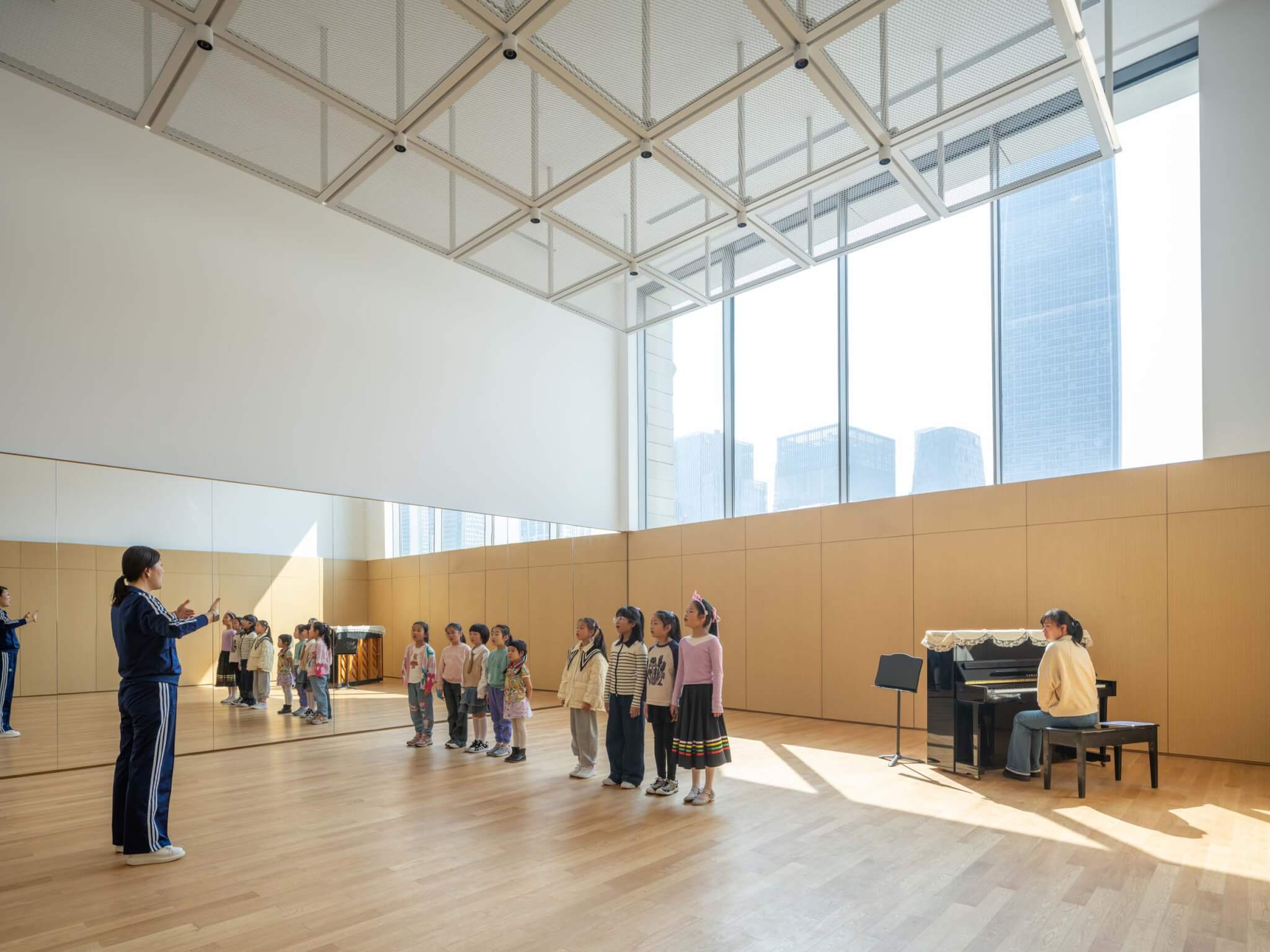 children chorus practicing inside west bund theatre