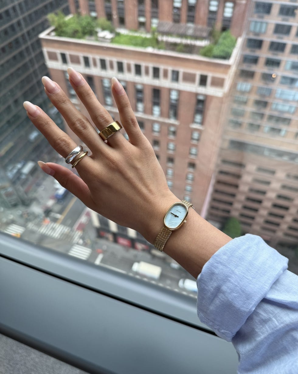 hand displaying jewelry against a city backdrop