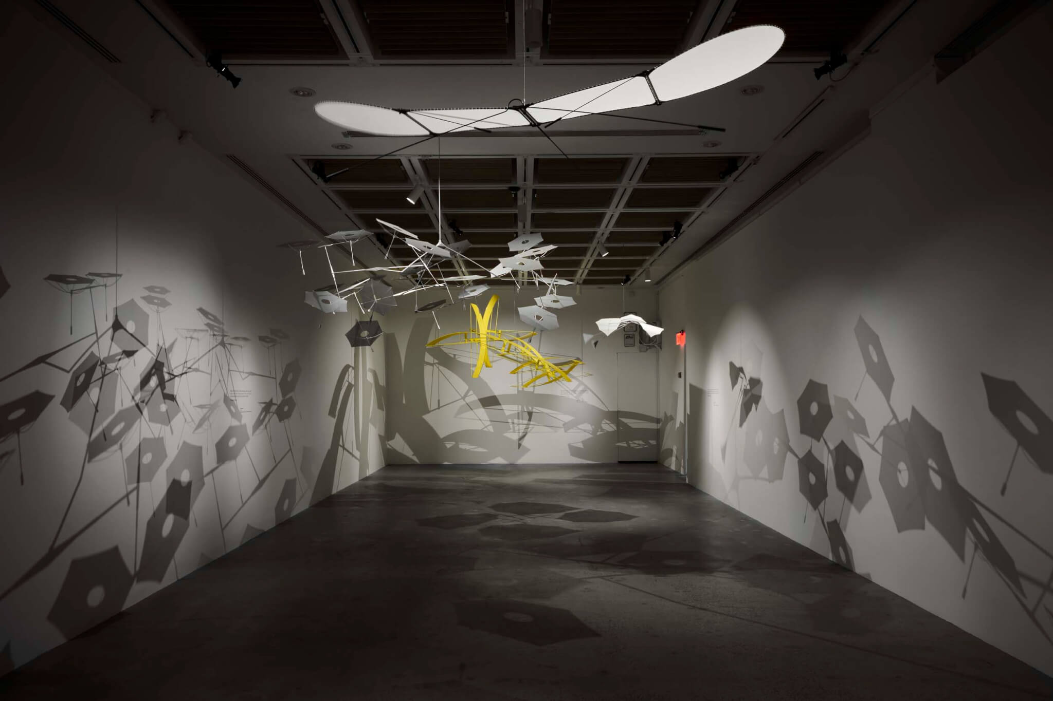 dark room with sculptures hanging from ceiling