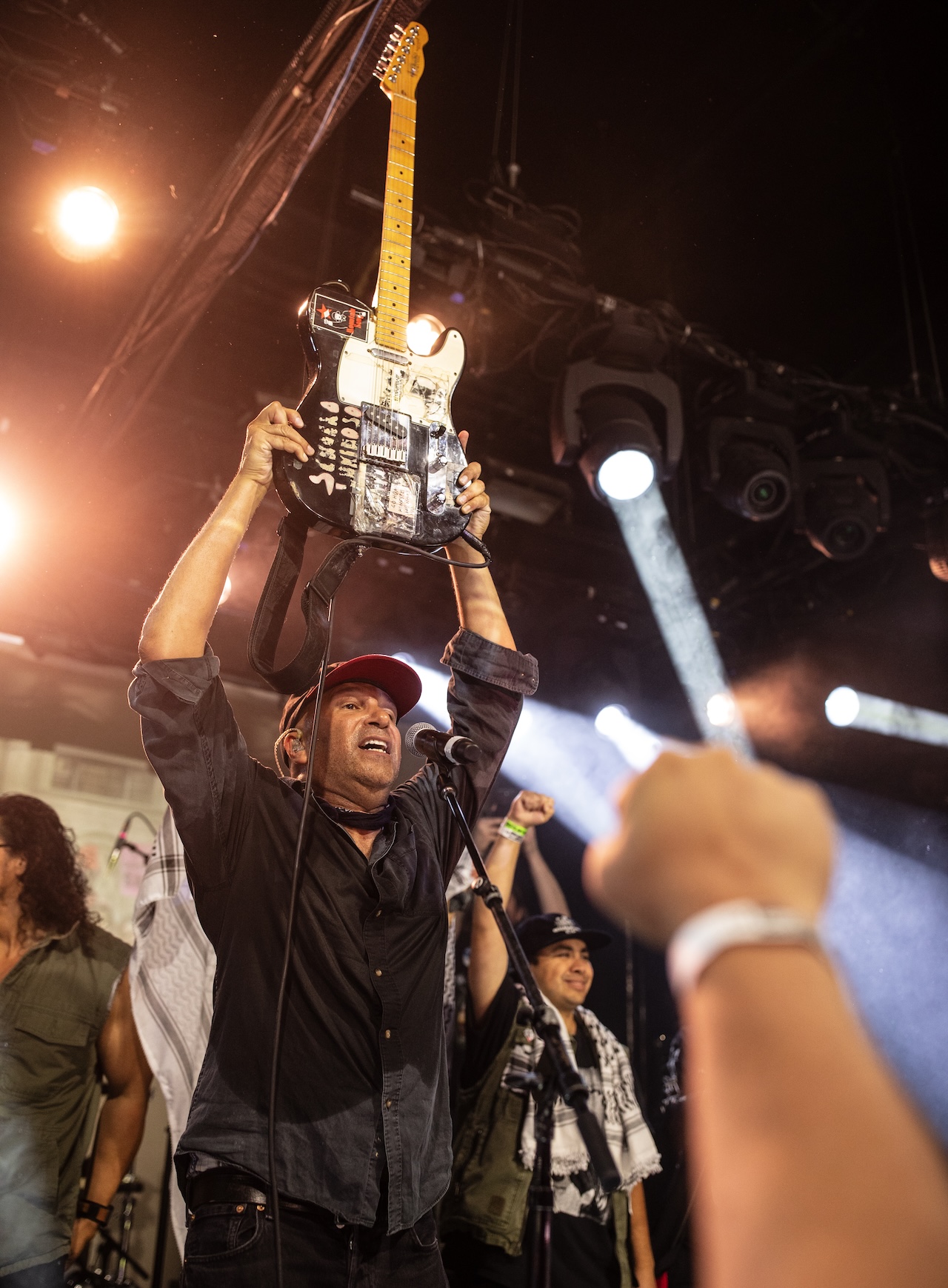 Tom Morello hold his guitar in triumph at his 