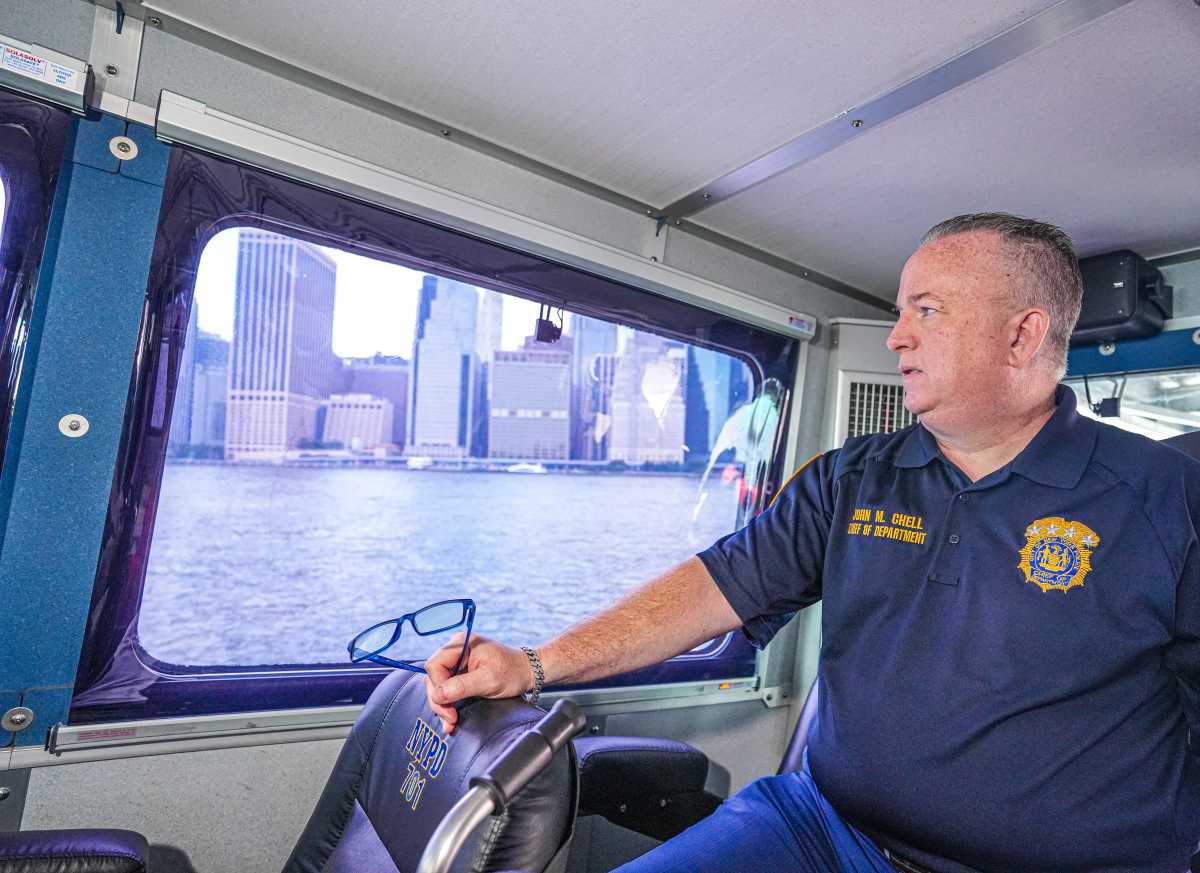 Fourth of July: NYPD Chief of Department John Chell talks 'all-hands-on-deck' approach to Macy's Fireworks Extravaganza security 2 Man in NYPD shirt at the helm of boat in New York Harbor