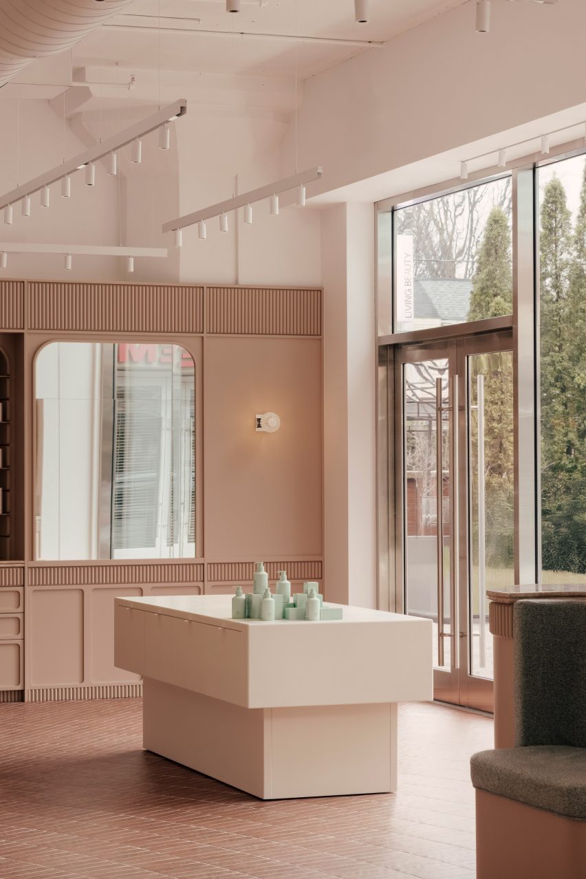 White Corian display plinths against clay-toned millwork