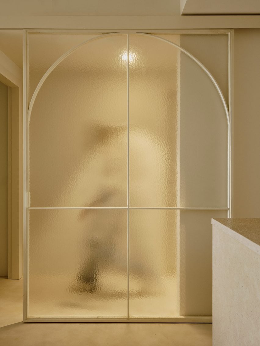 A figure walking behind a translucent glass door