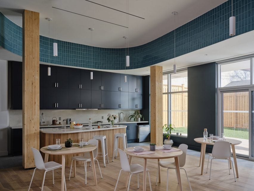 A communal kitchen and dining room with wooden furniture