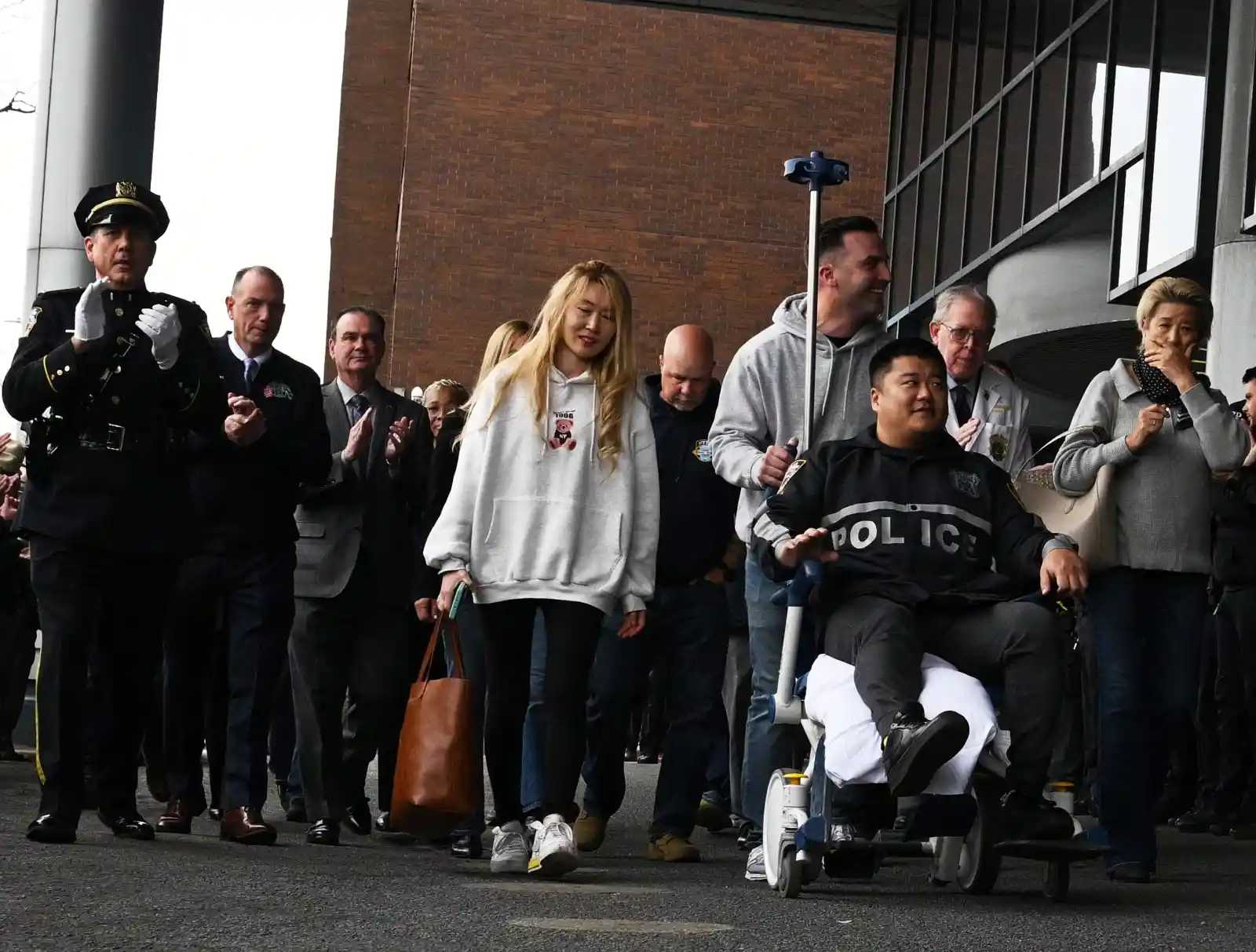NYPD Police Officer Rich Wong waved as he was wheeled out of Jamaica Hospital on Nov. 20.