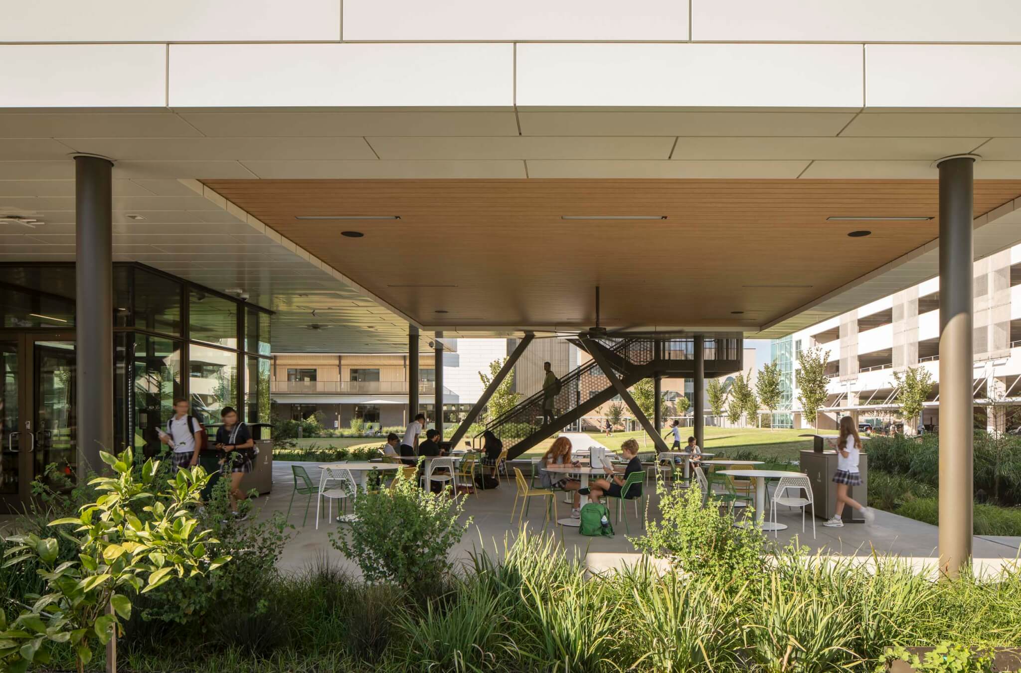 tables and chairs underneath raised part of the building