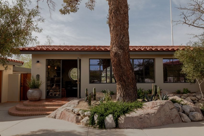 Exterior of a building with a terracotta-tiled roof surrounded by desert plants