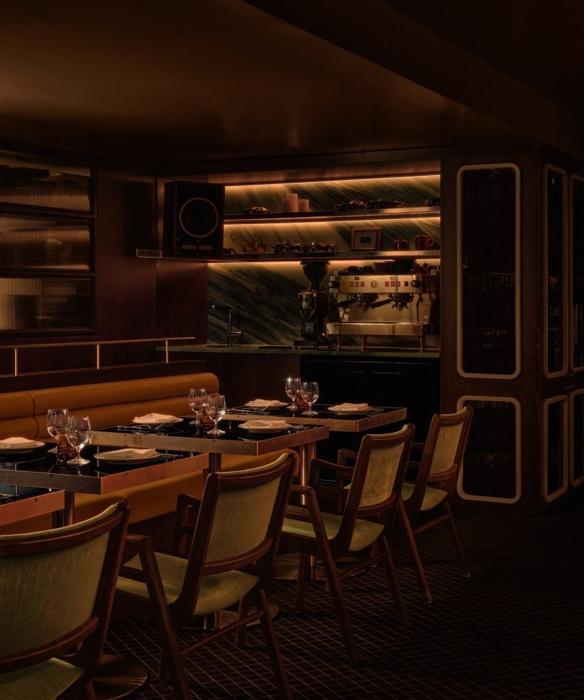 Glossy black tables positioned against tubular tan leather banquettes
