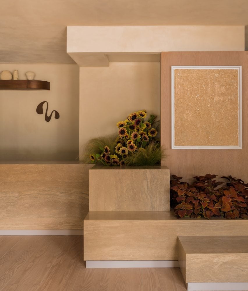 Stepped stone displays with floral planters, and an artwork on the wall