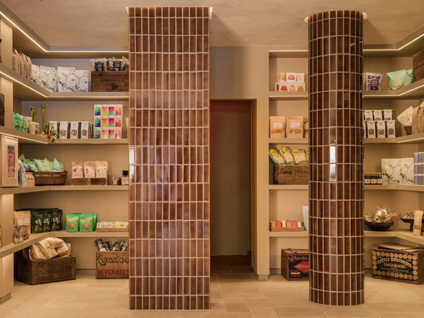 Mottled brown tiles wrap columns beside pantry goods