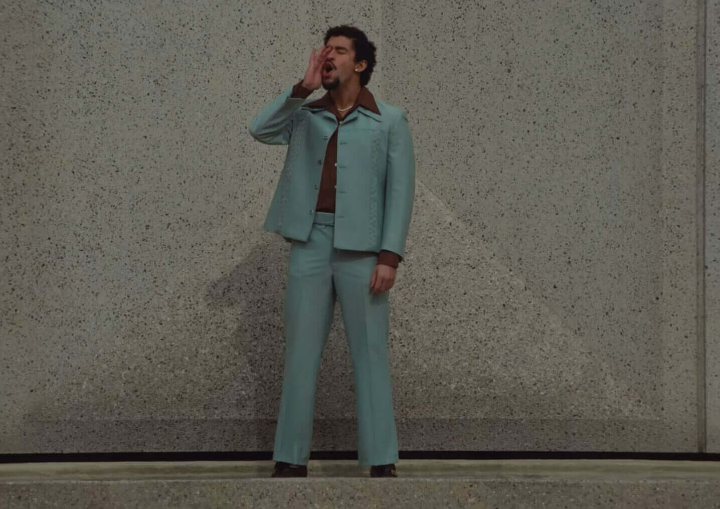 Bad Bunny standing in a blue suit