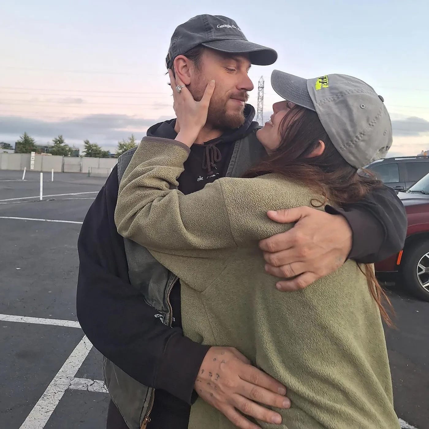 a couple embracing each other in a parking lot