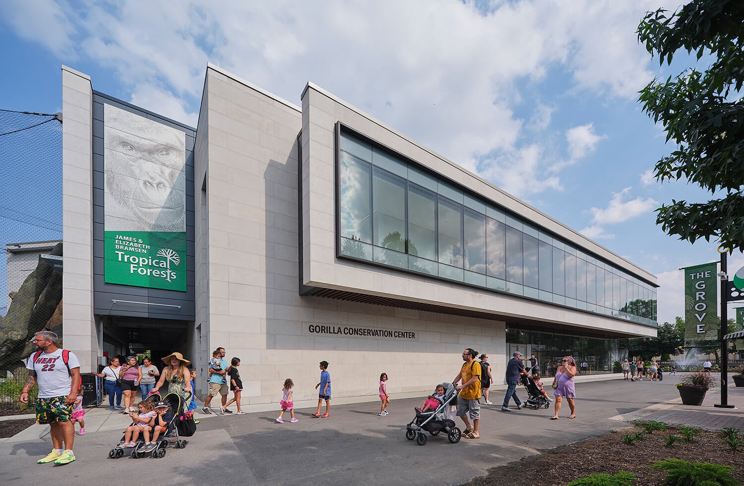 The entrance to the Gorilla Conservation Center at Brookfield Zoo Chicago with visitors, a large gorilla portrait banner, and Bramsen Tropical Forests signage