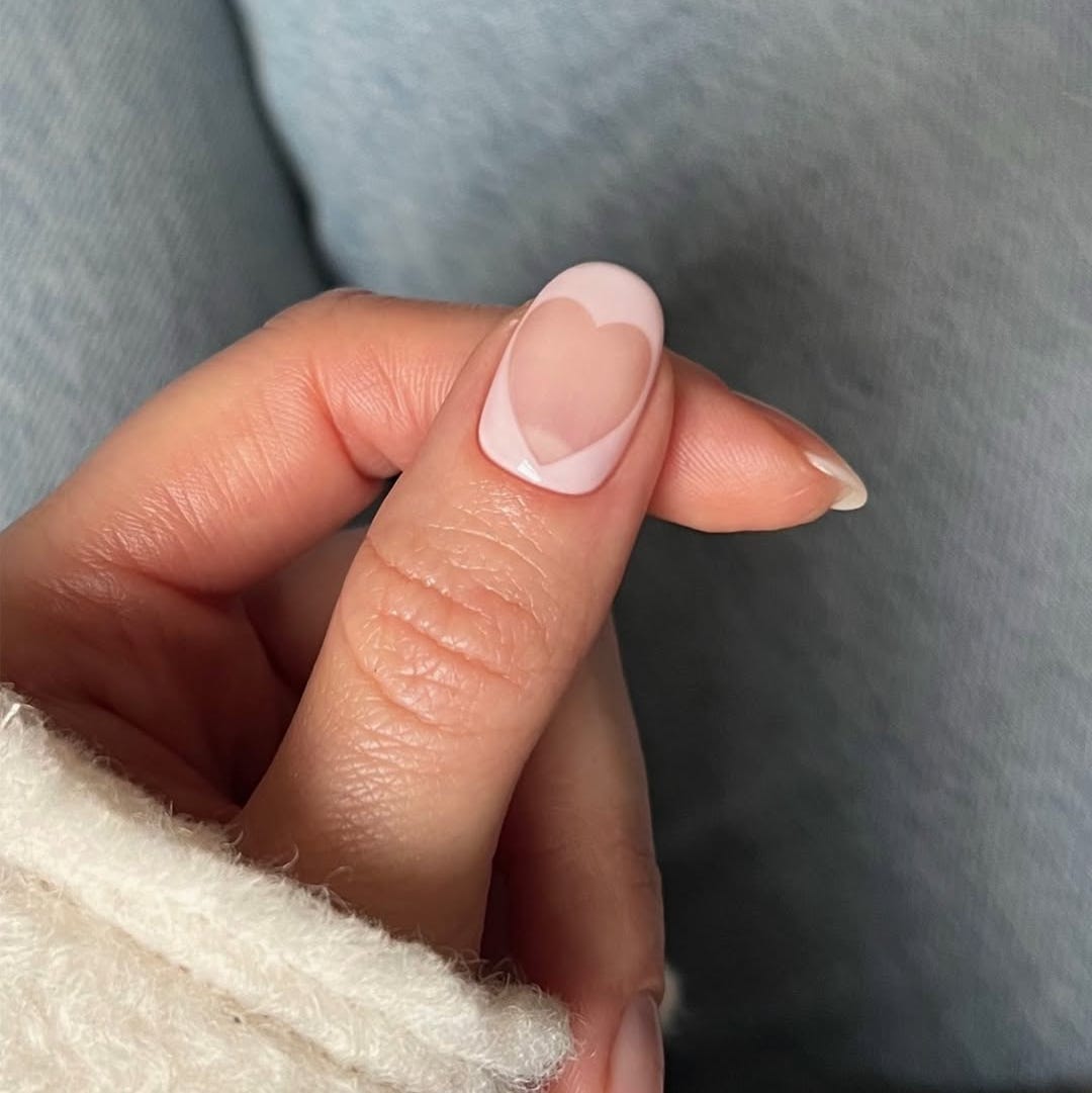 closeup of a manicured finger with a heartshaped nail design