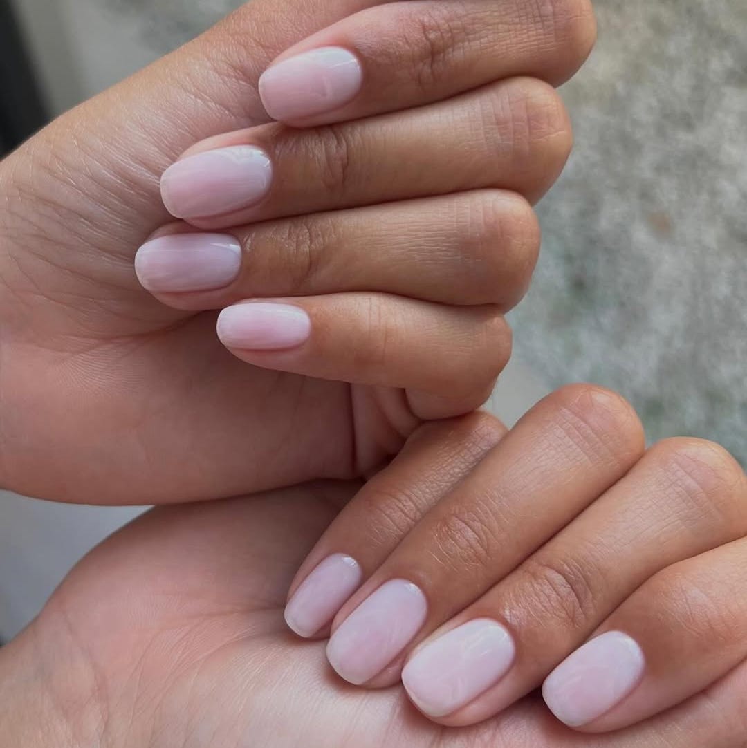 wellgroomed hands displaying manicured nails in a soft pink shade