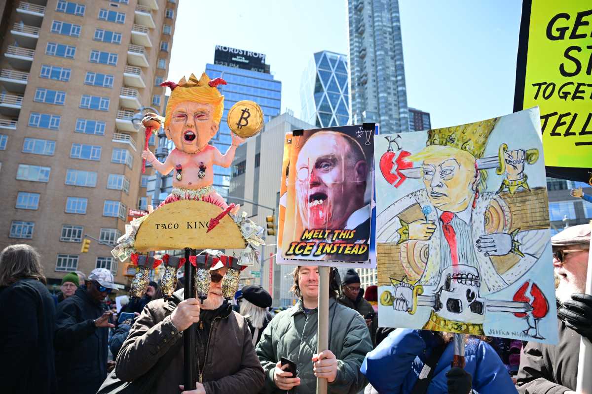New Yorkers hold signs against President Trump during the 
